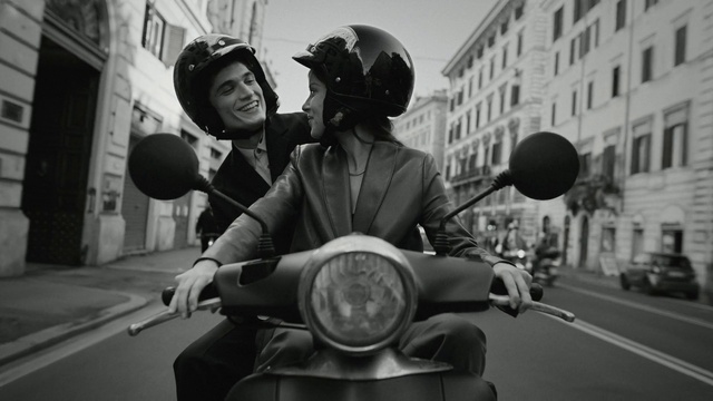 Video Reference: Motor vehicle, Helmet, Sky, Vehicle, Black, Automotive lighting, Building, Window, Automotive design, Smile