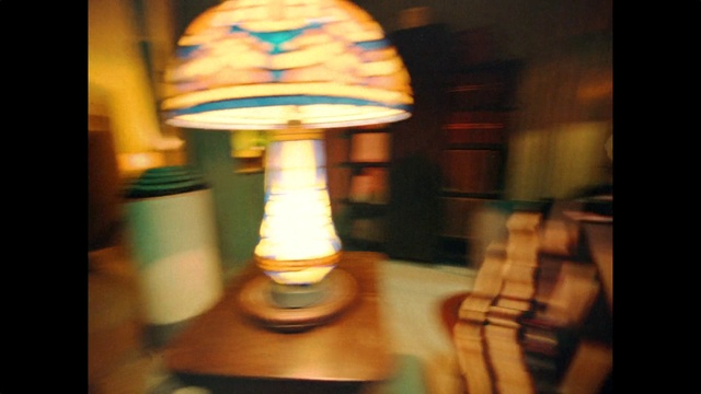 Video Reference: Lamp, Amber, Tints and shades, Indoor games and sports, Wood, Recreation, Glass, Lampshade, Gesture, Light fixture