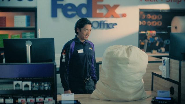 Video Reference: delivery, package, retail, counter, store, courier, FedEx Office, shipping, parcel, customer service, office, indoor, logistics, countertop, computer, work uniform