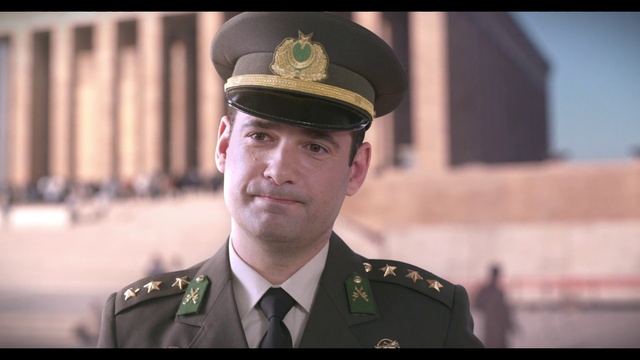Video Reference: Face, Outerwear, Military person, Military uniform, Coat, Dress shirt, Gesture, Tie, Peaked cap, Security