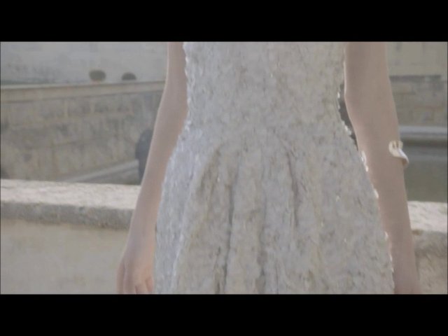 Video Reference: person, dress, white dress, outdoor, close-up, cropped, fashion, stone wall, water, daylight