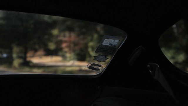 Video Reference: car interior, window, stickers, blurred background, outdoor view, travel, vehicle, dark interior, side window, bokeh, motion blur, roadside, daylight, landscape