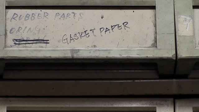 Video Reference: industrial, surface, handwritten, labels, rubber parts, gasket paper, dirty, scratched, close-up, factory, equipment, metal, text