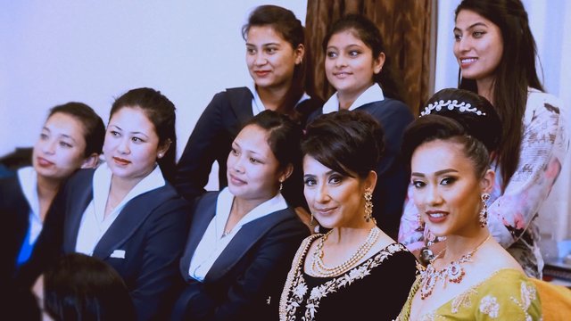 Video Reference: women, group, indoor, formal wear, traditional dress, portrait, social gathering, elegant, jewelry, ceremony, smiling, group photo