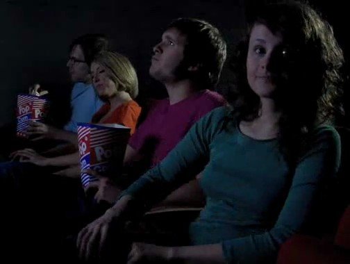 Video Reference: movie theater, audience, seated, popcorn, dark interior, cinema, people, row seating, watching film, foreground portrait, indoor