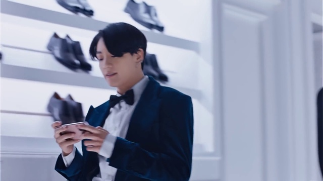 Video Reference: Microphone, Coat, Sleeve, Dress shirt, Gesture, Collar, Audio equipment, Headgear, Eyewear, Street fashion