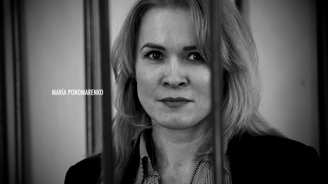 Video Reference: black and white, portrait, close-up, woman, face, bars, prison, serious, title text, interview, monochrome, dramatic, adult, indoor