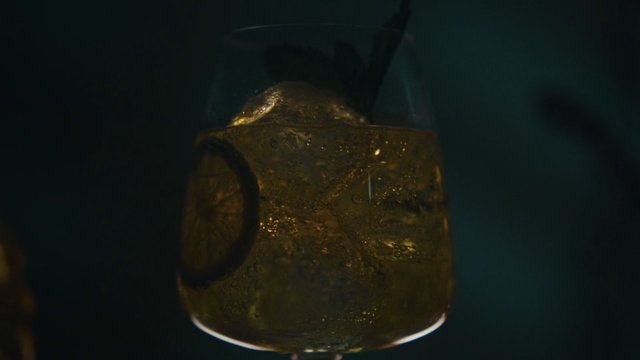 Video Reference: drink, glass, ice, beverage, close-up, macro, cold, refreshing, dark background, liquid, cocktail, rum, whisky, bar, moody, abstract