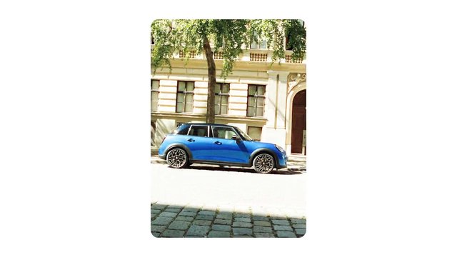 Video Reference: blue car, hatchback, parked car, street, building, tree, urban, sunny, exterior, transportation, side view, compact car, architecture, cobblestone