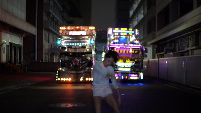 Video Reference: night, street, alley, dance, person, truck, decorated truck, colorful lights, urban, motion blur, dark, vehicle, nighttime, festival, performance