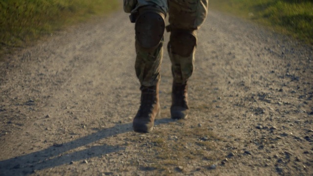 Video Reference: Leg, Road surface, Military camouflage, People in nature, Plant, Asphalt, Gesture, Grass, Thigh, Knee