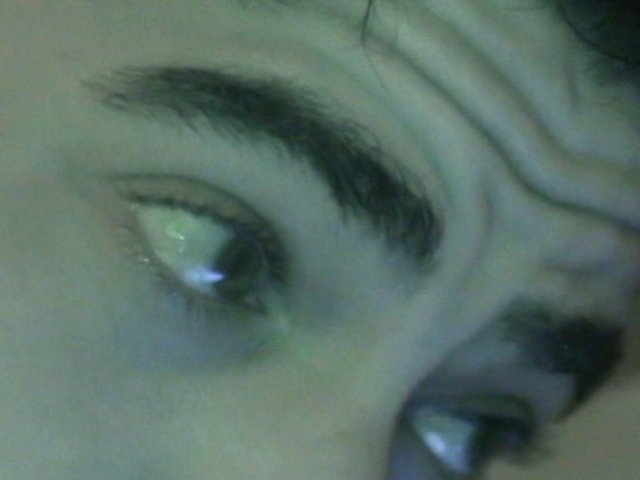 Video Reference: close-up, eye, eyebrow, face, person, low-light, green tint, video frame, macro, portrait, skin, gaze