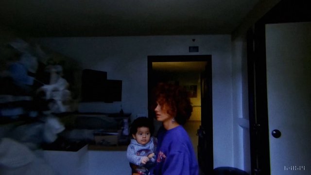 Video Reference: indoor, home, woman, child, doorway, family, dim light, interior, standing, holding baby, room, night, casual, portrait, blurred, home scene