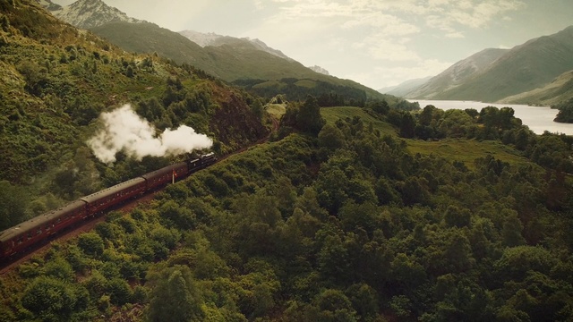 Video Reference: Cloud, Sky, Train, Mountain, Plant, Highland, Vegetation, Natural landscape, Rolling stock, Atmospheric phenomenon