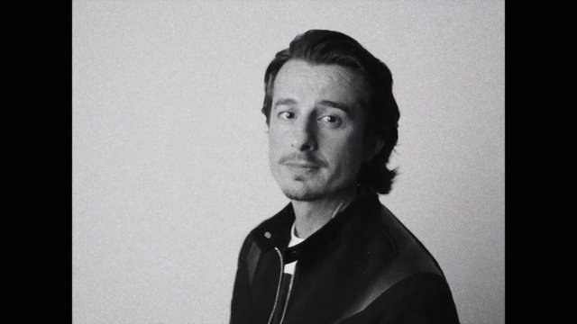 Video Reference: Forehead, Cheek, Flash photography, Jaw, Neck, Sleeve, Standing, Style, Collar, Black-and-white