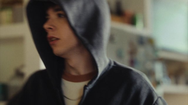 Video Reference: person, hoodie, close-up, indoor, blurred, portrait, casual, young adult, side view, shallow focus