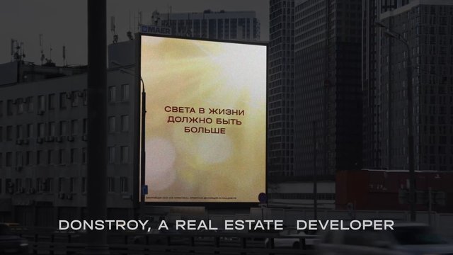 Video Reference: billboard, city, urban, advertisement, digital screen, Russian text, buildings, real estate, street, downtown, outdoor, signage, architecture, night, caption