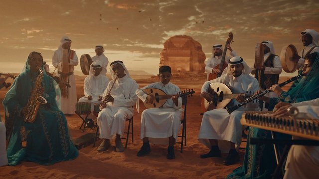 Video Reference: musicians, desert, sunset, traditional clothing, Middle Eastern, ensemble, instrument, oud, flute, saxophone, percussion, cultural performance, outdoor, group, sand, evening