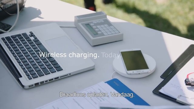 Video Reference: wireless charging, smartphone, laptop, charging pad, tabletop, electronics, office, technology, screen text, subtitle, device, desk, modern, portable, product demo
