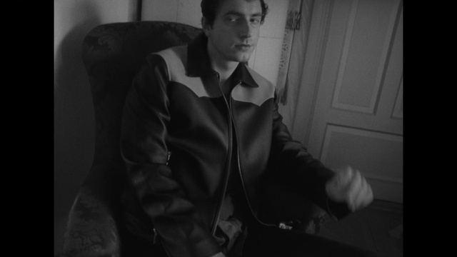 Video Reference: Dress shirt, Flash photography, Sleeve, Gesture, Black-and-white, Collar, Style, Blazer, Elbow, Chest