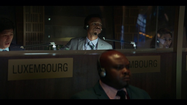 Video Reference: Forehead, Brown, Microphone, Coat, Public address system, Tie, Audio equipment, Spokesperson, Event, Blazer