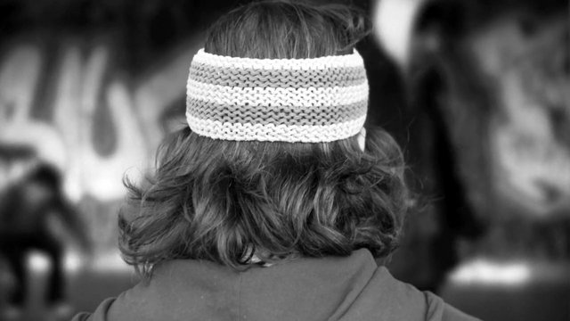 Video Reference: black and white, rear view, person, headband, knit, hair, blurred background, indoor, close up, portrait, back of head, fashion
