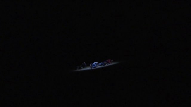 Video Reference: dark, night, people, lying down, ground, spotlight, stage, minimal, group, indoor, shadow, dramatic