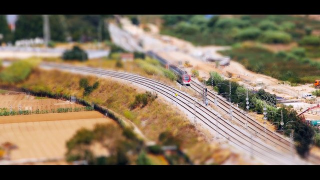 Video Reference: railway, train, aerial view, farmland, construction, tracks, tilt shift, rural, landscape, transportation, infrastructure, curving tracks