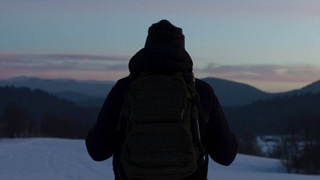 Video Reference: Cloud, Sky, Outerwear, Mountain, Snow, Highland, Standing, Tree, Luggage and bags, Terrain