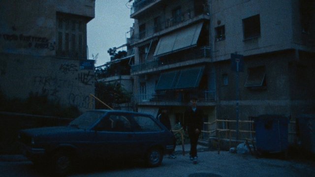 Video Reference: street, apartment buildings, car, people, urban, dusk, low light, narrow alley, residential, outdoors, vintage look