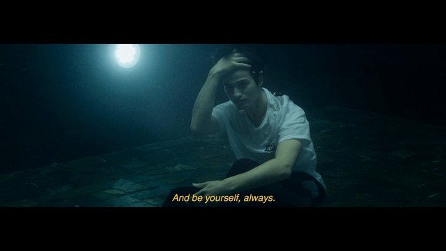 Video Reference: person, sitting, dark scene, dramatic lighting, subtitles, indoor, floor, tiled floor, white shirt, melancholy, cinematic, low light