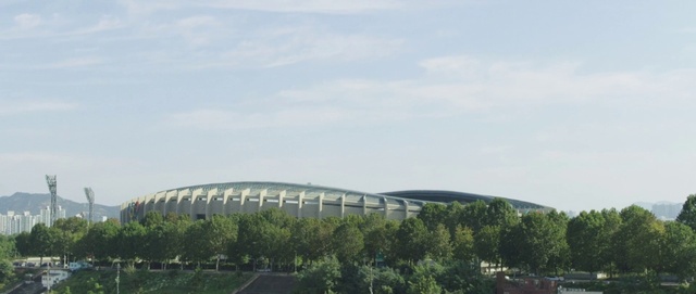Video Reference: Sky, Cloud, Building, Urban design, Grass, Tree, Landscape, City, Facade, Sport venue