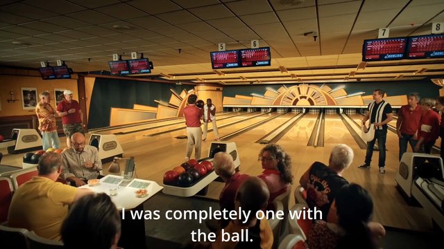 Video Reference: bowling, bowling alley, group, people, indoor, lanes, bowling ball, scoreboards, leisure, sports, social gathering, game, seated audience, subtitles