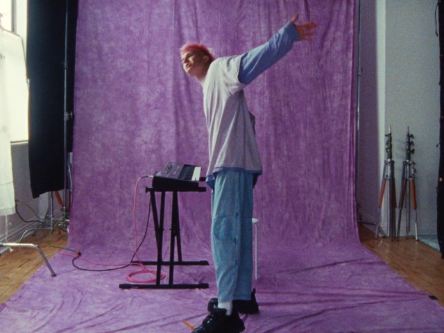 Video Reference: Purple, Curtain, Flooring, Wood, Entertainment, Audio equipment, Magenta, Performing arts, Event, Artist