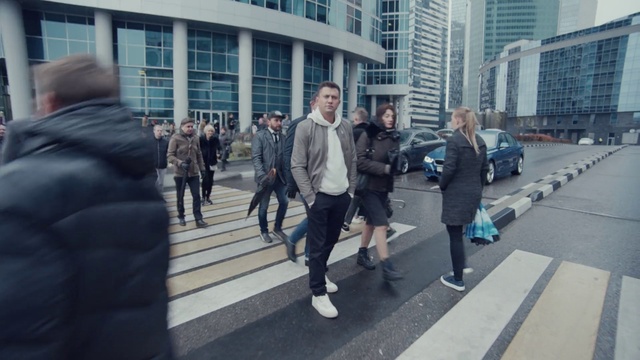 Video Reference: Building, Window, Infrastructure, Standing, Zebra crossing, Street fashion, Shorts, Asphalt, Sidewalk, Road surface
