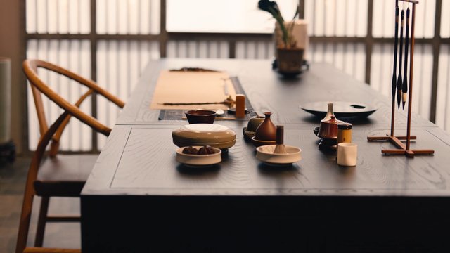Video Reference: dining table, tea set, tableware, interior, wooden chair, minimalist, traditional, ceramic, home decor, potted plant, soft light, still life, restaurant, table setting
