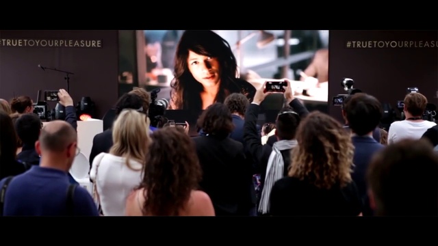 Video Reference: Gadget, Entertainment, Crowd, Event, Fashion design, Job, T-shirt, Display device, Audio equipment, Audience