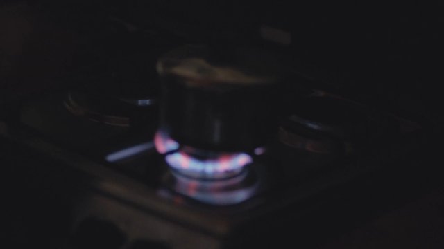 Video Reference: gas stove, burner, flame, cooking, cooktop, kitchen, close-up, dark, blurry, heat, fire, appliance