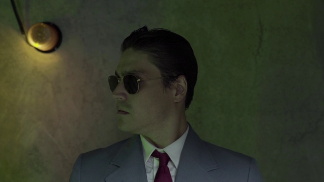 Video Reference: Forehead, Nose, Glasses, Chin, Eyebrow, Vision care, Facial expression, Tie, Dress shirt, Flash photography