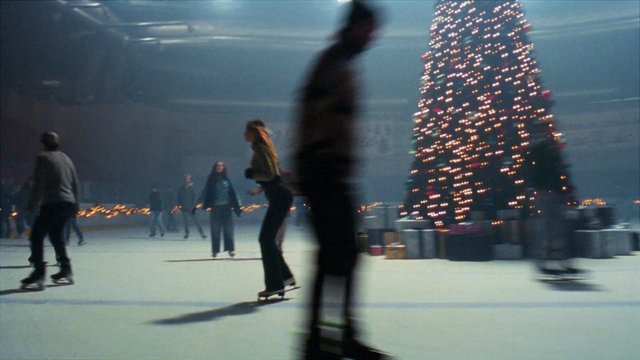 Video Reference: ice skating, indoor rink, christmas tree, holiday lights, winter, people, skaters, motion blur, festive, recreation, holiday, ice, night, decorated tree