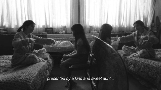 Video Reference: black and white, indoor, women, child, seated, bedroom, living room, curtains, family, conversation, interior, subtitles