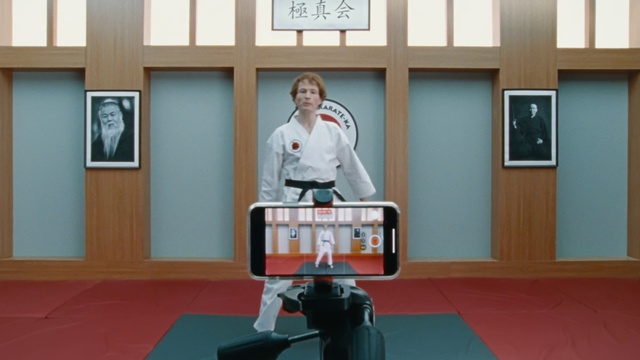 Video Reference: Picture frame, Flooring, Martial arts uniform, Machine, Event, Display device, Room, Sitting, Cinematographer, Cameras & optics