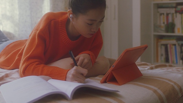 Video Reference: Head, Hand, Hairstyle, Arm, Shelf, Book, Comfort, Writing implement, Homework, Office supplies