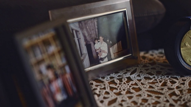 Video Reference: Wood, Suit, Event, Flooring, Room, Font, Display device, Metal, Glass, Fashion accessory