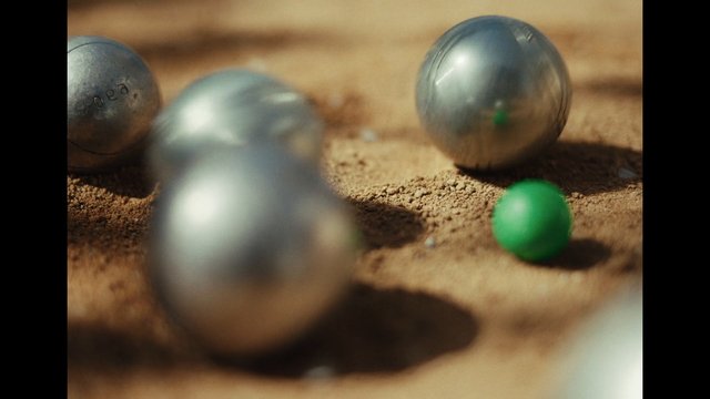 Video Reference: balls, metallic, green, sand, close-up, macro, shallow depth of field, blur, texture, outdoor, game pieces, still life