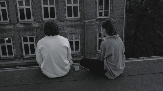 Video Reference: Window, Standing, Gesture, Building, Road surface, Black-and-white, Grey, Style, Tints and shades, City