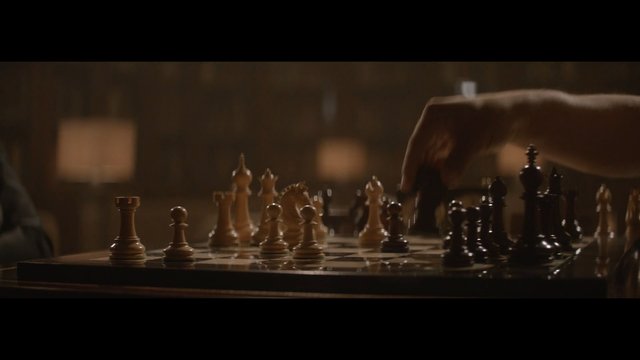Video Reference: chess, chessboard, hand, game, strategy, move, pieces, board, indoor, dimly lit, close-up, selective focus, competition, planning