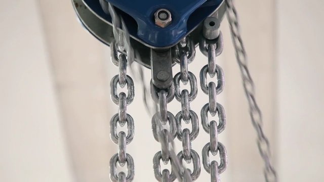 Video Reference: chains, metal, pulley, hoist, mechanical, industrial, close-up, hardware, equipment, steel, suspension, linkage, machine, background