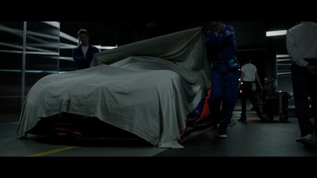 Video Reference: car, covered car, unveiling, garage, studio, crew, vehicle, sheet, automotive, indoor, dim light, workshop, mystery, drama