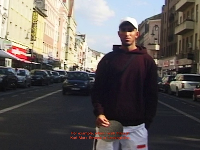 Video Reference: Car, Vehicle, Building, Sky, Street fashion, Sleeve, Asphalt, Tire, Hat, Travel